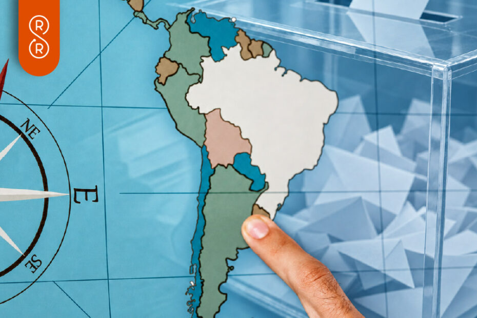Mapa electoral de Iberoamérica: mano que señala América del Sur junto a una urna transparente